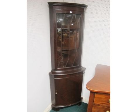 A PAIR OF MAHOGANY BOW FRONT CORNER CABINETS with astragal glazed doors the base with cupboard on bracket feet 118cm (h) x 53