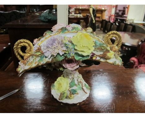 A DRESDEN FLOWER ENCRUSTED BOW SHAPED BOWL the white ground with gilt scroll handles raised on a circular foot 23cm (h) x 35c