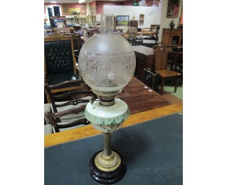A VICTORIAN BRASS OIL LAMP the etched glass shade above a painted resevoir raised on cylindrical column and circular spreadin