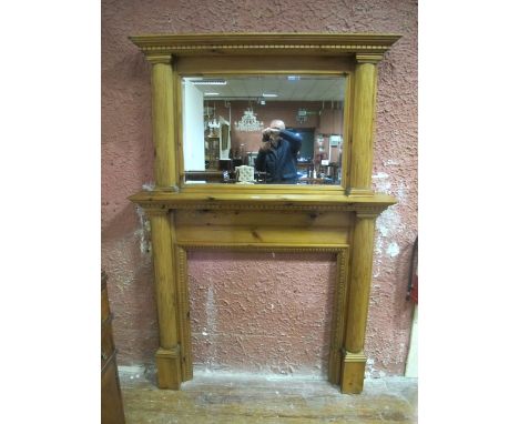 A PINE CHIMNEY PIECE with overmantle the bevelled glass plate with outswept moulded cornice raised on reeded half pilasters a
