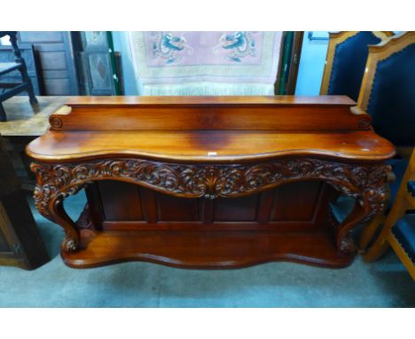 A Rococo style carved mahogany serpertine console table 