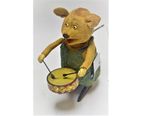 A Schuco clockwork Pig Drummer,  flesh coloured felt body and head,  dressed in blue dungarees, ribbon bow tie, tin drum, lon