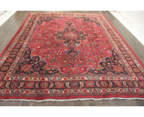 A North West Persian Woollen Carpet, with a central medallion amongst an all over design upon a red, blue and cream ground wi