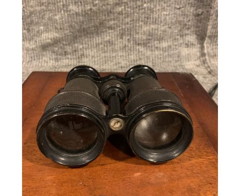 A Pair of vintage binoculars with black leather covered casing and black enamel trim, a compass is inset in the cross bar of 