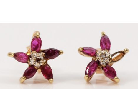A pair of 9ct gold ruby and diamond floral earrings with scroll backs, one setting vacant, 1.2g