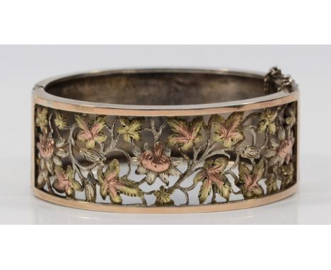 A Victorian silver, two colour gold and cut work floral bangle, Birmingham 1883, with spring clasp, 57 x 50mm, 25mm wide, 35g