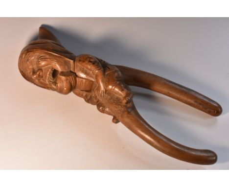 A Black Forest novelty lever-action nut cracker, carved as a gnome, full-length, 27.5cm long, early 20th century