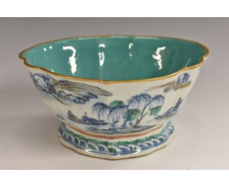 A 19th century Chinese fluted trefoil dish, painted in underglaze blue and green with figures and sampans in a mountainous la