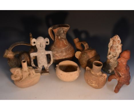 A Peruvian spouted vessel, modelled in the Typical pre-Columbian manner as a grotesque face, the broad open mouth showing two
