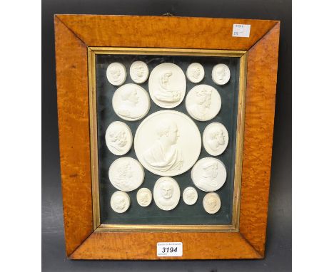 An arrangement of plaster intaglios, mostly profile portrait medallions, 24.5cm x 19.5cm, maple frame