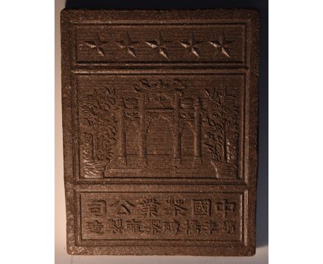 A Chinese rectangular tea brick, in relief with a palace gate, stars and script, the verso in sixteen sections, 24cm high, 18