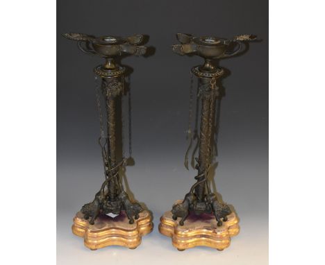 A pair of 19th century Grand Tour dark patinated bronze tripod candlesticks, each crested by a detachable 'oil lamp' after th