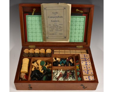 An early 20th century mahogany games box, hinged cover enclosing an arrangement of compartments with playing pieces, 32.5cm w
