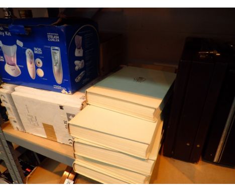 Shelf of mixed items including Encyclopedia Britannica and Facial machine