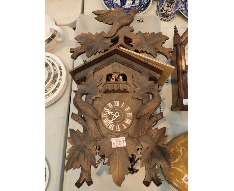 Large cuckoo clock with rotating figurines weights pendulum and top decoration 