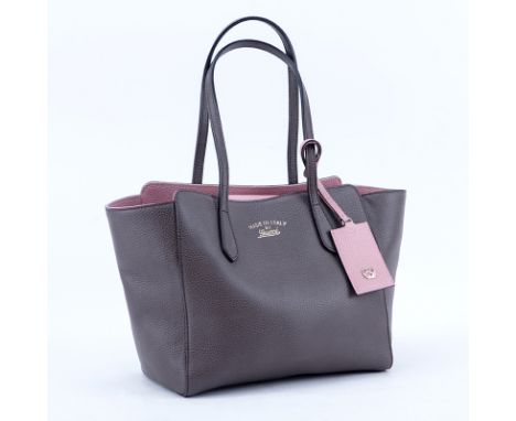 Gucci Taupe/Light Pink Grained Leather Swing PM Handbag. Gold tone hardware, interior of beige fabric with zippered and patch