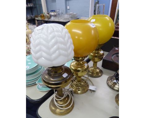 NEAR PAIR OF VICTORIAN BRASS OIL LAMPS, EACH WITH YELLOW GLOBE SHADES, ONE WITH GLASS FUNNEL, THE OTHER ADAPTED; ANOTHER ADAP