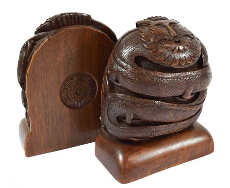 A Pair of Anglo-Indian Hardwood Bookends, each carved in the form of a scrolling dragon with inset red glass eyes, internally