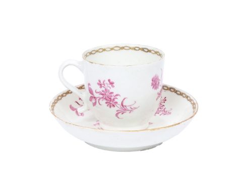 A LOWESTOFT PORCELAIN COFFEE CUP AND SAUCER. with monochrome puce floral spray decoration, within gilt pierced oval borders, 