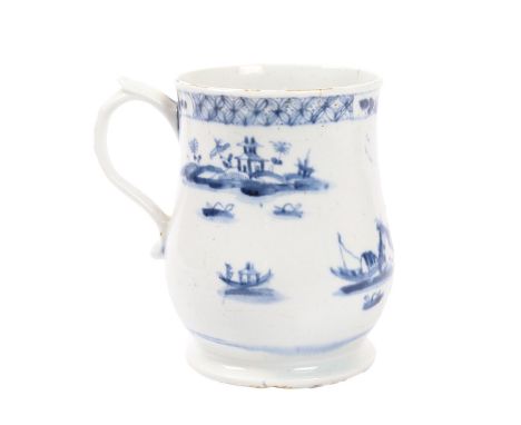 A RARE AND EARLY LOWESTOFT PORCELAIN MUG, CIRCA 1760-62. Of bell shape with a turned foot and S-shaped handle with a thumbres