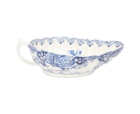 A RARE LOWESTOFT PORCELAIN SAUCEBOAT. the fluted body with lattice and scroll decorated exterior, the interior decorated in a