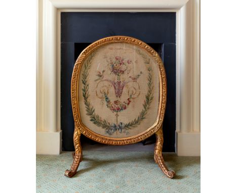 A 19th century oval giltwood firescreen, the foliate and egg &amp; dart decorated frame raised on foliate and scale supports 