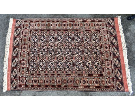 A part-silk Tekke Bokhara rug, the three rows of eight gols on a light brown field, within a repeating medallion and wine gla