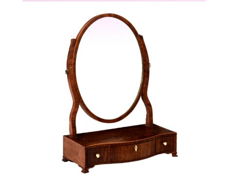 A George III mahogany serpentine box base toilet mirror, the oval mirror on shaped uprights, over a boxwood strung base with 