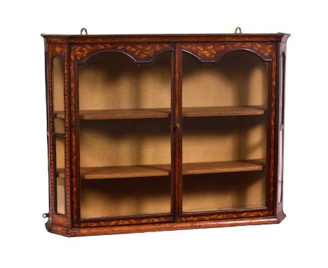 An early 19th century walnut and Dutch marquetry glazed hanging cabinet, the cavetto moulded top over a pair of arch glazed d