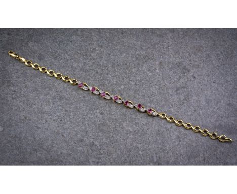 An 18ct yellow gold, ruby and diamond bracelet, featuring 7 pear cut rubies interspersed within 7 pavé set diamond and yellow