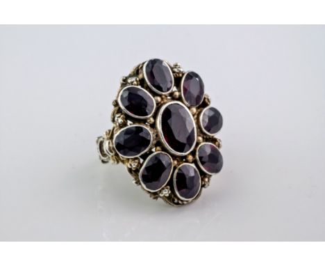 A garnet and silver gilt ring, probably Indian in origin and featuring 8 oval cut garnets around a marginally larger, central