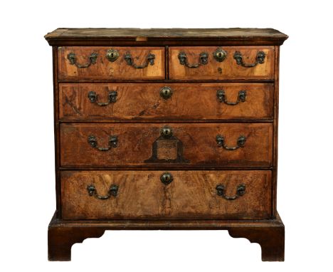 Irish (Butler family) interest - A George I walnut chest of drawers, the ogee moulded cross banded top over two short and thr