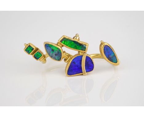 An unusual handmade 18ct yellow gold and black opal double shank ring, the two open shanks with various abstractly shaped opa