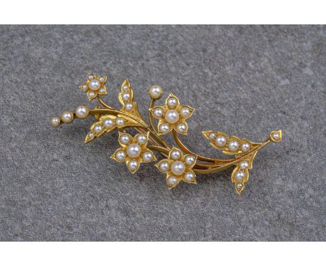 A vintage yellow gold and seed pearl floral spray brooch, in the shape of a flower vine and with a pin clasp to the back. Mea