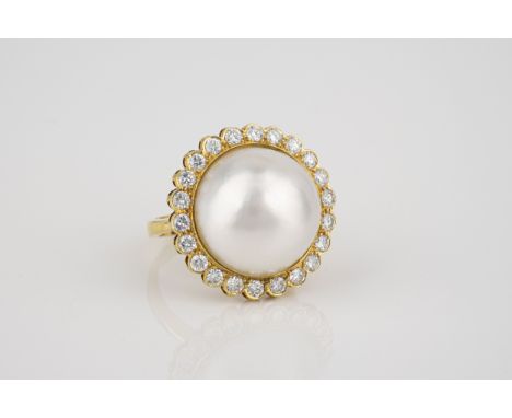 An 18ct yellow gold, Mabé pearl and diamond dress ring, the 17mm. pearl within a border of 22 brilliant cut diamonds, size M.