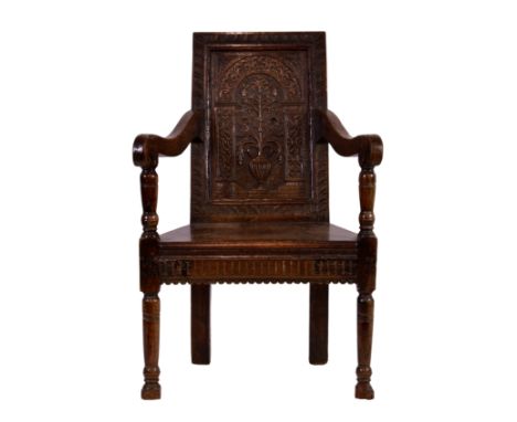 A 17th century and later oak Wainscot chair, the rectangular panelled back with a carved bas relief panel with a flowering pl