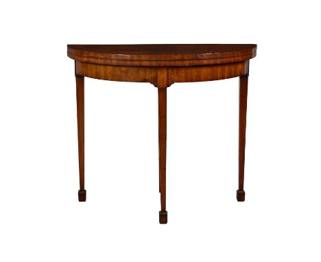 A Continental early 19th century mahogany demi-lune card table, the baize lined and feather banded top opening on a pull out 