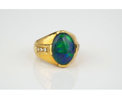 An 18ct yellow gold, black opal and diamond ring, the oval opal over broad, tapering shoulders, each set with three brilliant