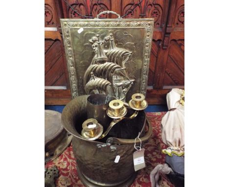 A brass spark guard, helmet shaped fire bucket, candlestick and mortar shell