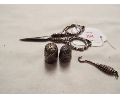 A pair of Birmingham 1896 silver handled scissors, silver miniature button hook and two silver thimbles