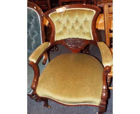An Edwardian mahogany tub shaped button-back elbow chair having carved back resting on short cabriole legs 