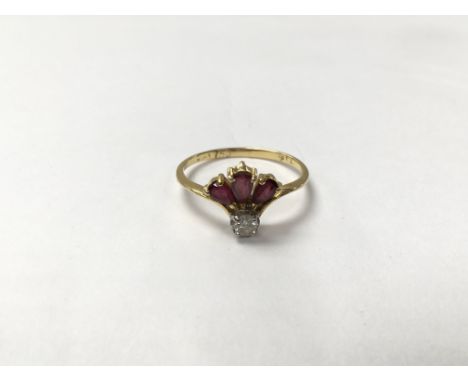 An 18ct gold ring set with three rubies and a diamond. The approximate ring size is between K and L.