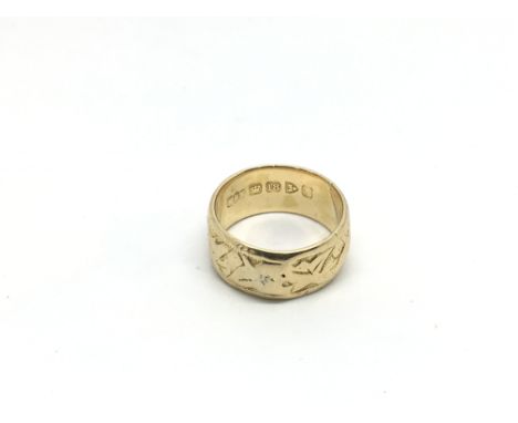 An 18ct gold ring with embossed design, approx 3.3g and approx size K.