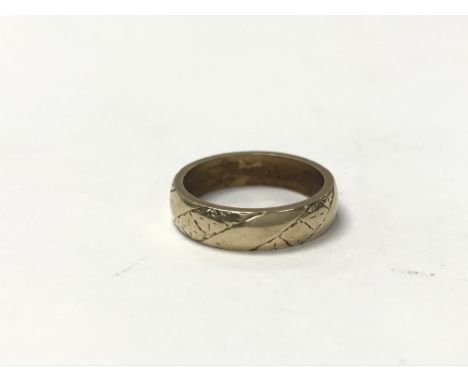 A 9ct gold band ring with light engraving, weighing approximately 5.75g and measuring in ring size approximately O - P.