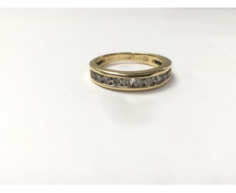 An 18ct gold ring set with a row of diamonds, measuring approximately ring size K.