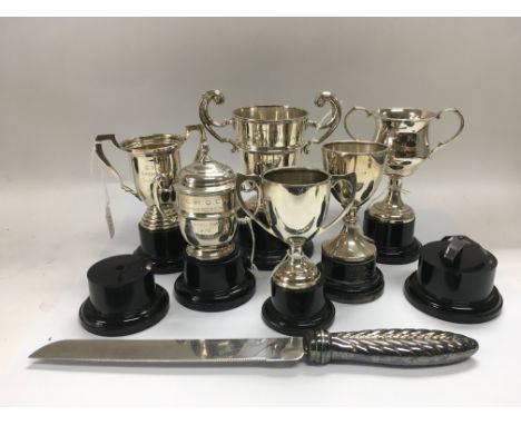 A collection of silver trophy cups and a silver handled knife.