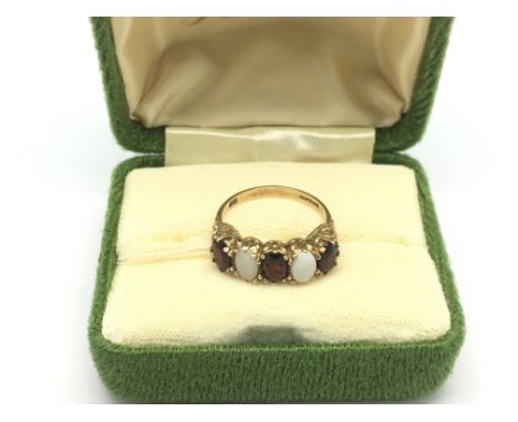 A 9ct gold ring set with opals and garnets, approx 2.5g and approx size K.