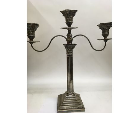 A silver candle stick with Corinthian column on step base Birmingham hallmarks., with later silver plated two branch candelab