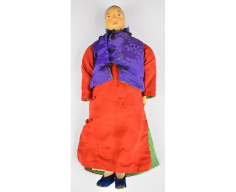 Chinese 'Door of Hope' doll wearing a pink dress and purple silk jacket, height 22cm