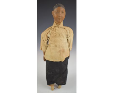 Chinese 'Door of Hope' doll wearing a black dress and cream jacket, with carved bun hairstyle, height 28cm